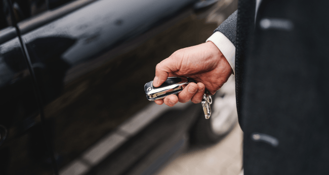 Close up of a man in suit locking his car.